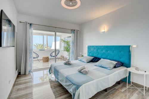 a bedroom with a large bed with a blue headboard at Ocean View Apartment Montesol I in Adeje