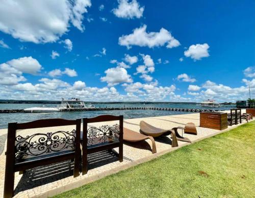 a couple of benches sitting next to the water at View467LifeResortBR in Brasilia