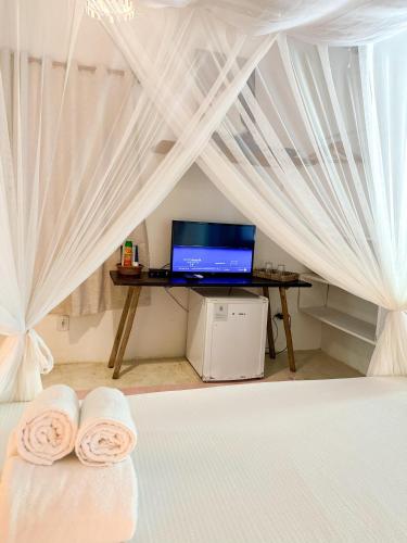 a bedroom with a bed with a desk with a laptop at Casa da Glória Trancoso - Pousada Boutique in Trancoso