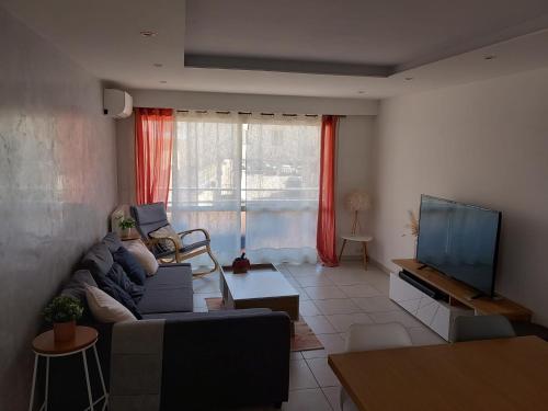 sala de estar con sofá y TV de pantalla plana en Appartement 1er étage, 66 m² en La Seyne-sur-Mer