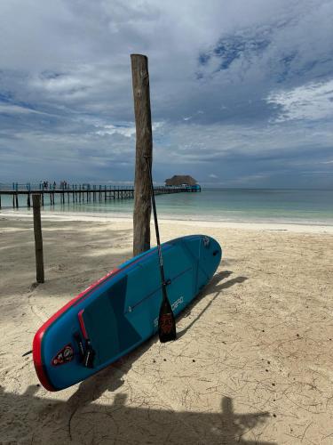 a surfboard tied to a pole on the beach at Kiwengwa Bungalow Boutique Resort in Kiwengwa