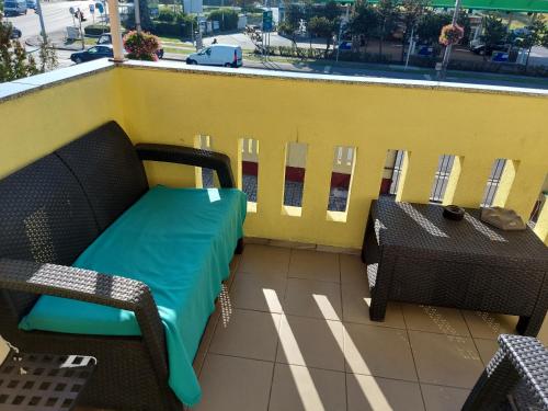 einen Balkon mit einer Bank und Tischen auf einem Gebäude in der Unterkunft Corner Apartman 5 in Siófok