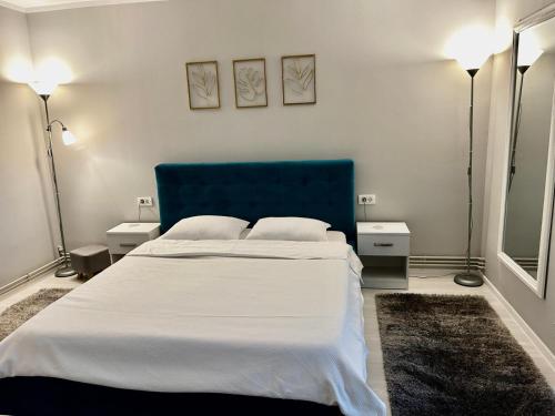 une chambre avec un grand lit et une tête de lit bleue dans l'établissement Elina studio, à Drobeta-Turnu Severin