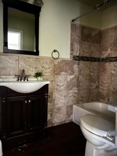 ein Badezimmer mit einem Waschbecken, einem WC und einem Spiegel in der Unterkunft Private room in southern home in San Antonio