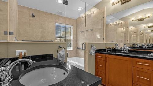 een badkamer met een wastafel, een douche en een bad bij Luxury Townhome - 5 minutes to Disney in Orlando