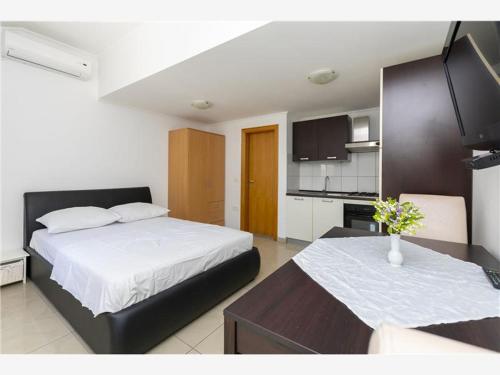um quarto com uma cama grande e uma cozinha em Apartmani Livajić em Duće