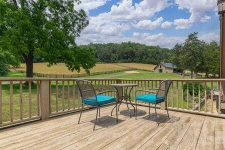 a patio with two chairs and a table on a deck at The Loft at Springhouse farm in Lexington
