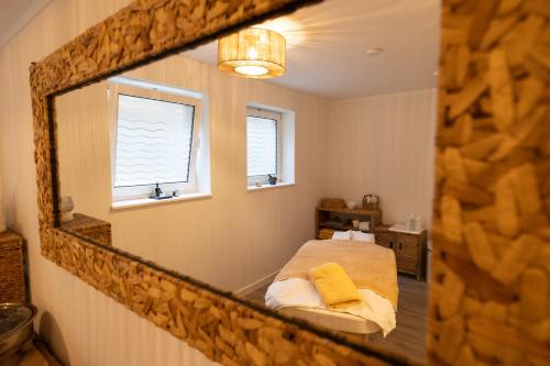 a reflection of a bedroom with a bed in a mirror at Seeblick Genuss und Spa Resort Amrum in Norddorf