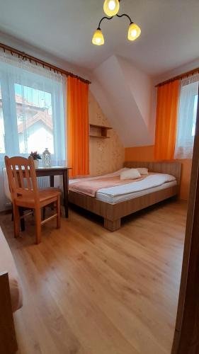 a bedroom with a bed and a chair and a desk at Pokoje goscinne, apartamenty Jas i Malgosia in Karwia