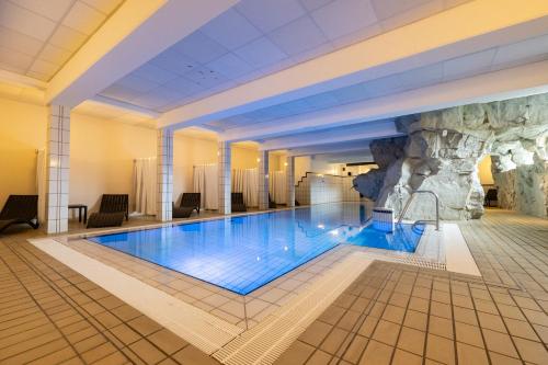 a hotel swimming pool with a rock wall at Seeblick Genuss und Spa Resort Amrum in Norddorf