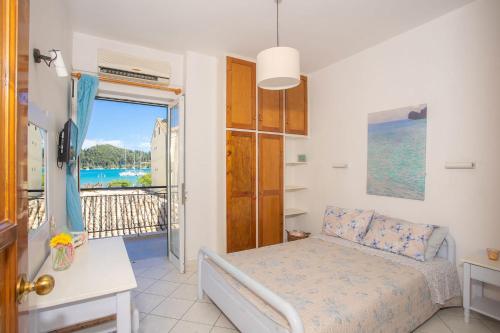 a bedroom with a bed and a view of the ocean at A1- Mikro Karavi Apartment in Nydri