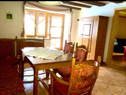 een eetkamer met een houten tafel en stoelen bij Ferdihof Holiday Home in Hierholz