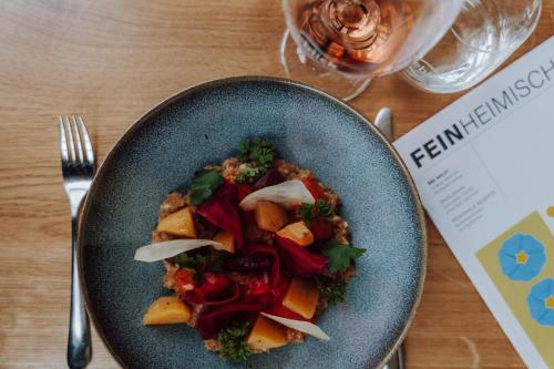 a blue plate of food on a wooden table at Seeblick Genuss und Spa Resort Amrum in Norddorf