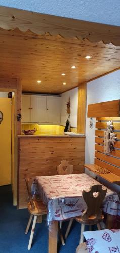 Cette chambre dispose d'une cuisine avec une table et un comptoir. dans l'établissement Appartement residence Chanteneige Les Menuires centre croisette au pieds des pistes, aux Menuires