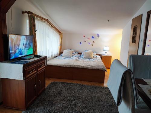 a bedroom with a bed and a flat screen tv at Dom wczasowy - Ferienwohnung in Ustka