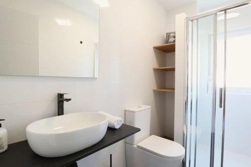 La salle de bains blanche est pourvue d'un lavabo et de toilettes. dans l'établissement Notel Club - Oasis urbano en Santander, à Santander