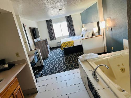 a hotel room with a bed and a bathroom at Baymont by Wyndham Piqua in Piqua