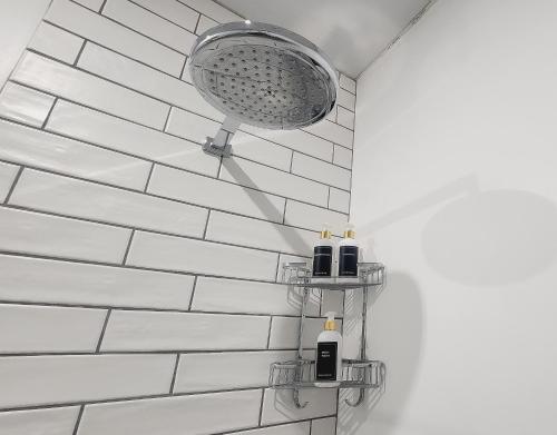 La salle de bains est pourvue d'une douche et de 2 distributeurs de savon. dans l'établissement Hanepoot 503, à Paarl