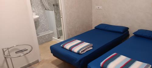 a small room with two beds and a bathroom at Albergue Santiago Apostol in Logroño