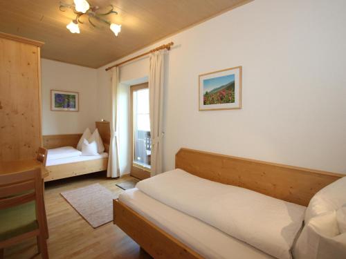 um quarto com uma cama, uma secretária e uma janela em Schleicherhof III em Strass im Zillertal