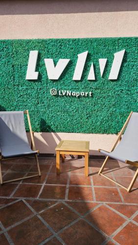 dos sillas y una mesa frente a una pared verde en LVN Apart en San Clemente del Tuyú