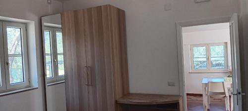 a room with a wooden cabinet and a table and window at Olive&Sea Villa-OLIVE in Mattinata