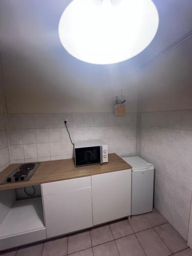 une cuisine avec un four micro-ondes sur un comptoir lumineux dans l'établissement Logement entier F2 Stade de France, à Saint-Denis