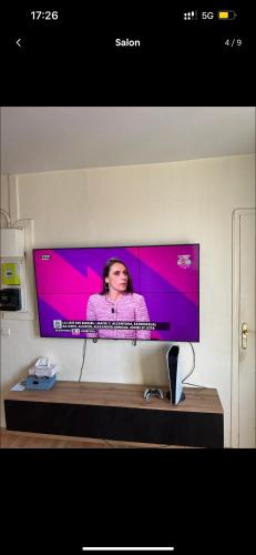 un téléviseur à écran plat posé sur une table dans l'établissement Logement entier F2 Stade de France, à Saint-Denis