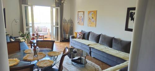 a living room with a blue couch and a table at Best Apartment La Cassia Beach & Golf Resort, Cabo Negro in Cabo Negro