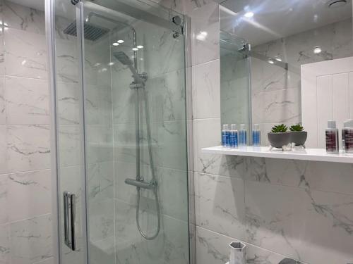 a shower with a glass door in a bathroom at Luxury 2 bedroom apartment in Belper