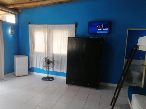 a blue room with a fan and a television on a wall at Punta Pacífico Bungalows Máncora in Máncora