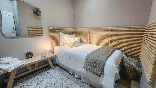 a bedroom with a bed and a table with a mirror at Hanepoot 503 in Paarl