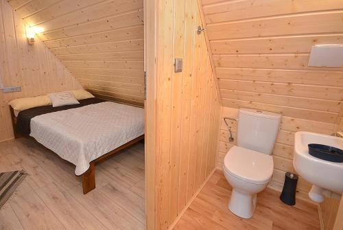 a small bathroom with a toilet and a sink at Domki SUNSET Bałtycka in Dąbki