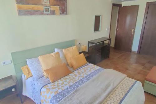 a bedroom with a bed with yellow and blue pillows at La Colina Playa&Golf in Huelva