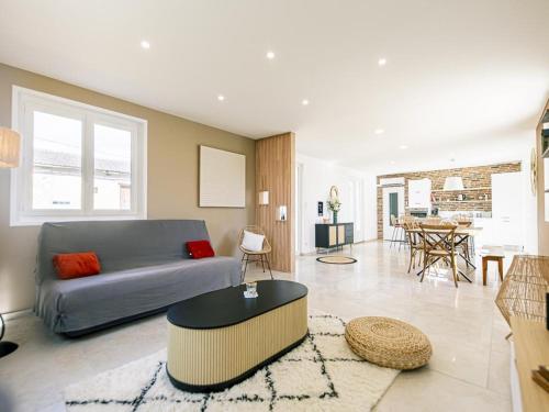 un salon avec un canapé et une table dans l'établissement Gîte de charme avec spa, terrasse et grand jardin, au cœur des vignobles entre Moulins et Vichy - FR-1-489-507, à Saulcet