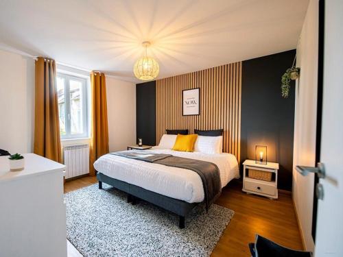una camera da letto con un letto e un lampadario di Gîte de charme avec spa, terrasse et grand jardin, au cœur des vignobles entre Moulins et Vichy - FR-1-489-507 a Saulcet