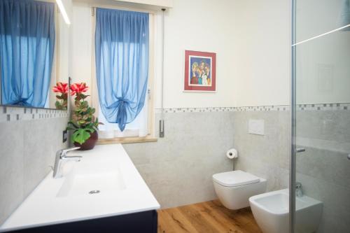 a bathroom with a sink and a toilet and a window at Casa Lina in Bardolino