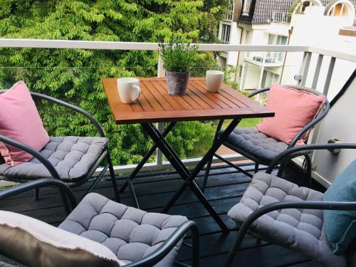 einen Tisch und Stühle auf einem Balkon mit einem Tisch in der Unterkunft Strandappartment Meerkieker in Travemünde