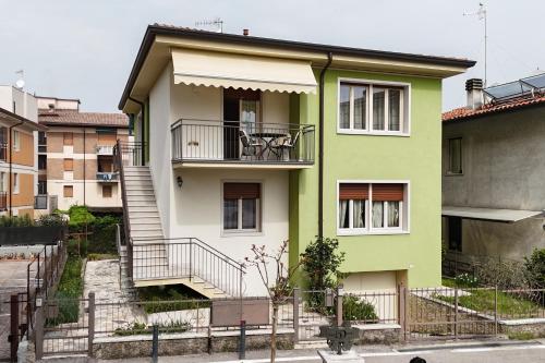 a green and white house with a balcony at Casa Lina in Bardolino