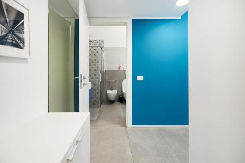 baño con puerta azul y aseo en Suite Meravigli - Incredibile posizione DUOMO e CASTELLO, en Milán
