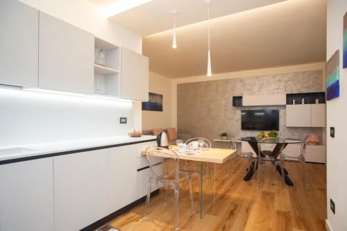 a kitchen with white cabinets and a table and chairs at Casa Lina in Bardolino