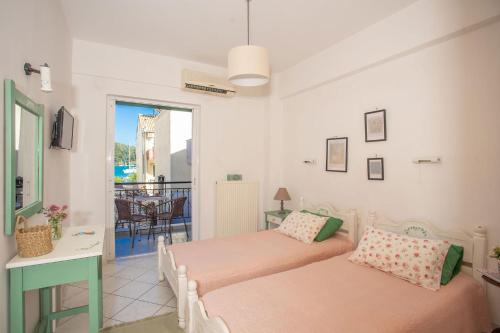 two beds in a room with a balcony at A2- Alexandri Apartment in Nydri
