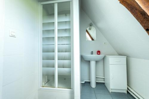 een badkamer met een wastafel en een glazen kast bij L'échappée belle in Fontenay