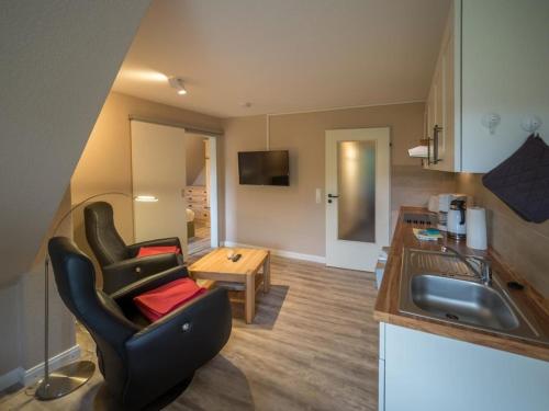 a kitchen with a chair and a table and a sink at Arche Svea Kiebitz in Spiekeroog