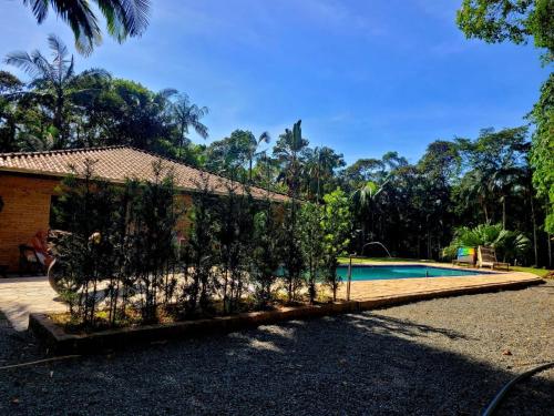 a villa with a swimming pool and a house at Sitio Bonanza in Guaratuba