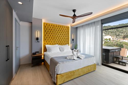 a bedroom with a large bed with a yellow headboard at Ennea Muses Rooms and Suites in Nafplio
