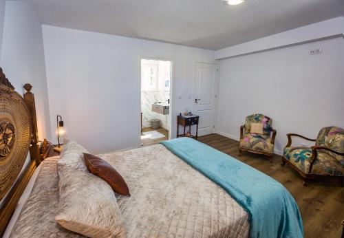 a bedroom with a large bed and a chair at Casa Lela Dumbria in Dumbría