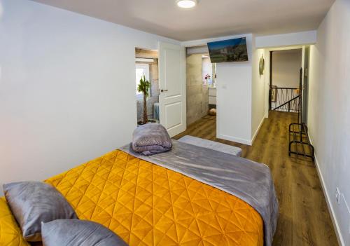 a bedroom with a bed with an orange blanket at Casa Lela Dumbria in Dumbría