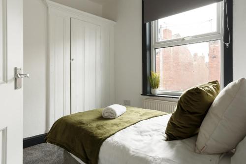 um quarto com uma cama e uma janela em Spacious Three-Bedroom Apartment in Leeds em Leeds