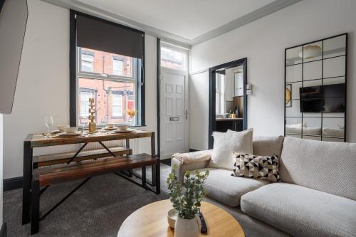 uma sala de estar com um sofá e uma mesa em Spacious Three-Bedroom Apartment in Leeds em Leeds